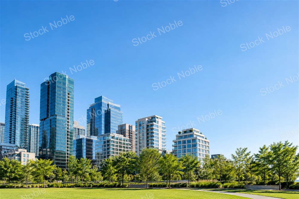 Modern Glass Towers Above a Green Summer Park and Lawn